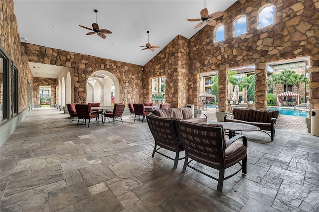 view of patio / terrace featuring an outdoor living space, ceiling fan, and an indoor pool