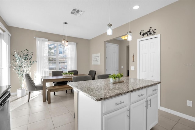 kitchen with light stone countertops, stainless steel dishwasher, decorative light fixtures, white cabinets, and a kitchen island