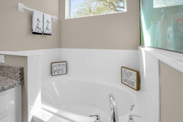 bathroom featuring vanity and a relaxing tiled tub