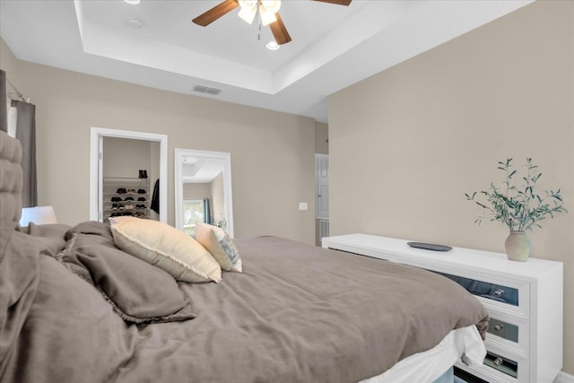 bedroom with a raised ceiling and ceiling fan