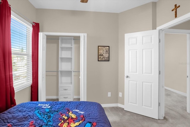 carpeted bedroom with ceiling fan and a closet