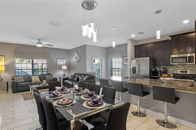 dining room with a wealth of natural light, sink, ceiling fan, and light tile patterned flooring