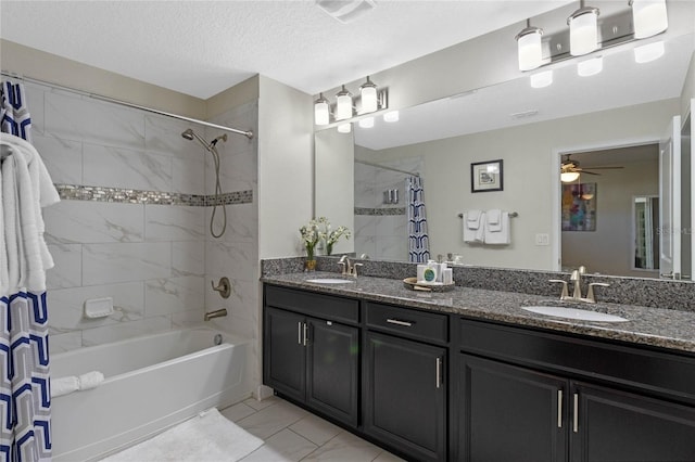 bathroom featuring ceiling fan, tile patterned flooring, a textured ceiling, shower / bath combo with shower curtain, and vanity