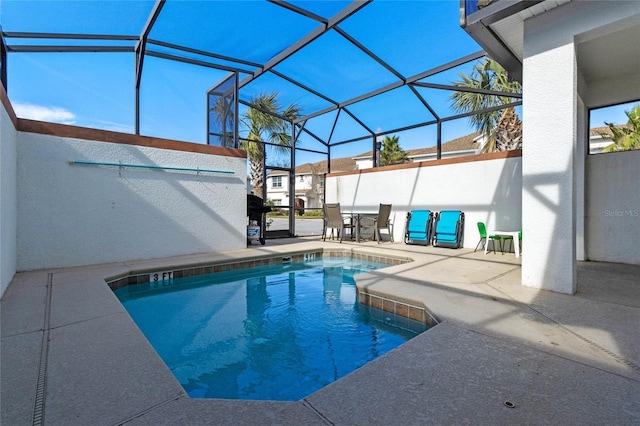 view of swimming pool with glass enclosure and a patio area