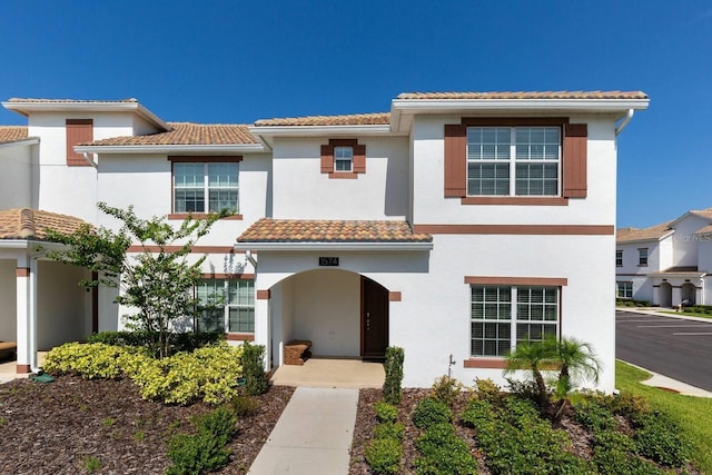 mediterranean / spanish-style home with stucco siding and a tile roof