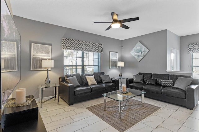 living area with marble finish floor and ceiling fan