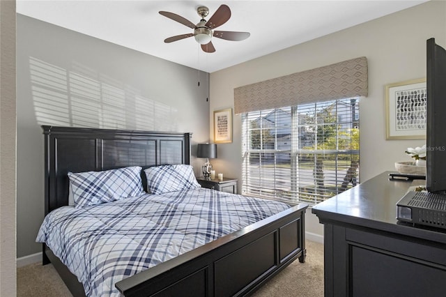 bedroom with baseboards, a ceiling fan, and light colored carpet