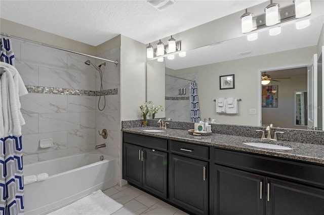full bath featuring double vanity, shower / bath combo with shower curtain, a ceiling fan, and a sink