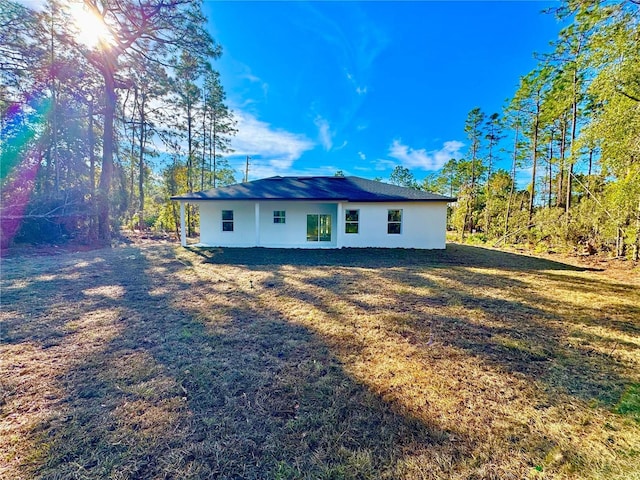 back of property featuring a yard