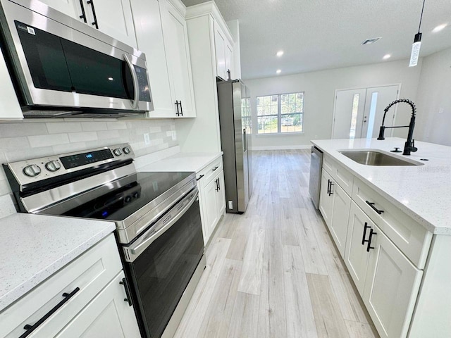 1523 W Citrus Springs Blvd, Citrus Springs, FL 34434 - kitchen featuring appliances with stainless steel finishes, light wood-style flooring, backsplash, white cabinets, and recessed lighting