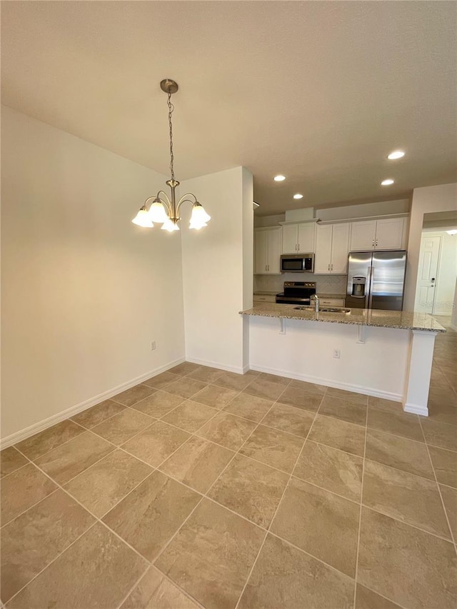 kitchen featuring hanging light fixtures, stainless steel appliances, a notable chandelier, kitchen peninsula, and white cabinets