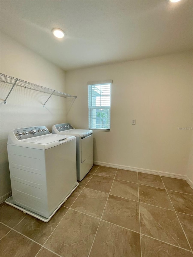 laundry room with washer and clothes dryer and light tile patterned floors