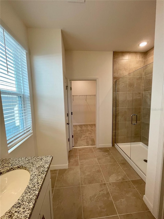 bathroom with tile patterned floors, vanity, and walk in shower