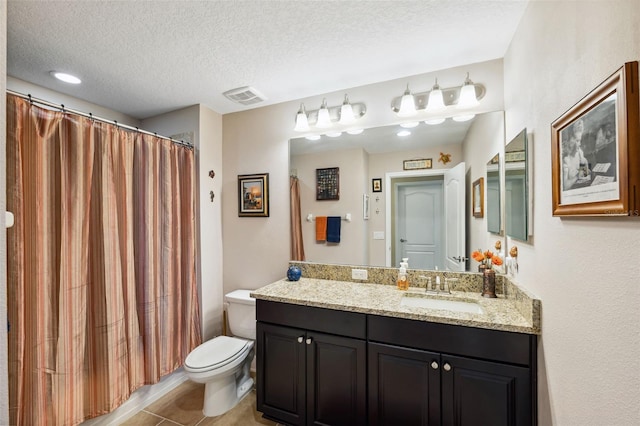 bathroom featuring tile patterned flooring, vanity, a textured ceiling, and toilet