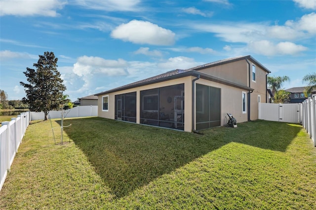 back of house featuring a sunroom and a yard