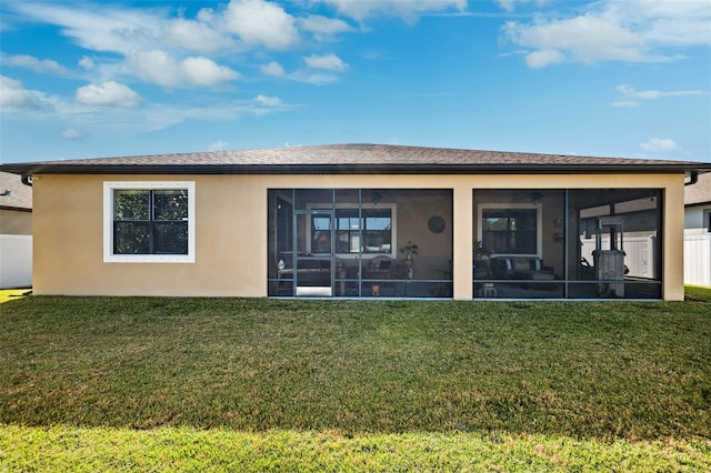 rear view of house with a sunroom and a lawn