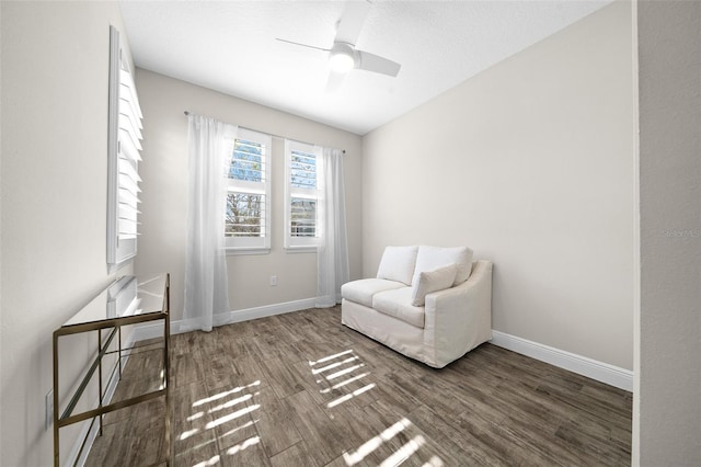 sitting room with dark hardwood / wood-style floors and ceiling fan