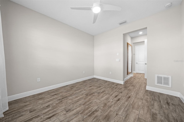 empty room with dark hardwood / wood-style floors and ceiling fan