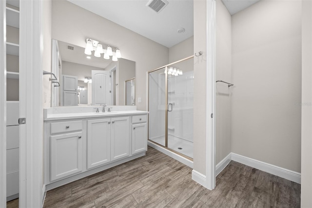 bathroom featuring hardwood / wood-style floors, vanity, and walk in shower