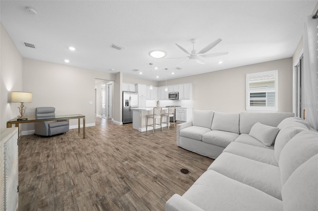 living room with ceiling fan and wood-type flooring