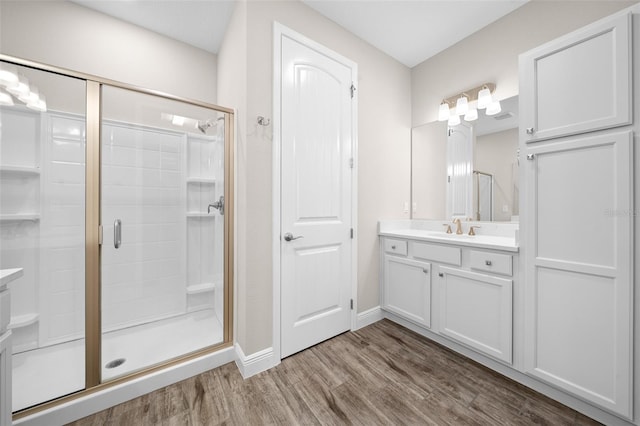 bathroom with vanity, hardwood / wood-style flooring, and a shower with door