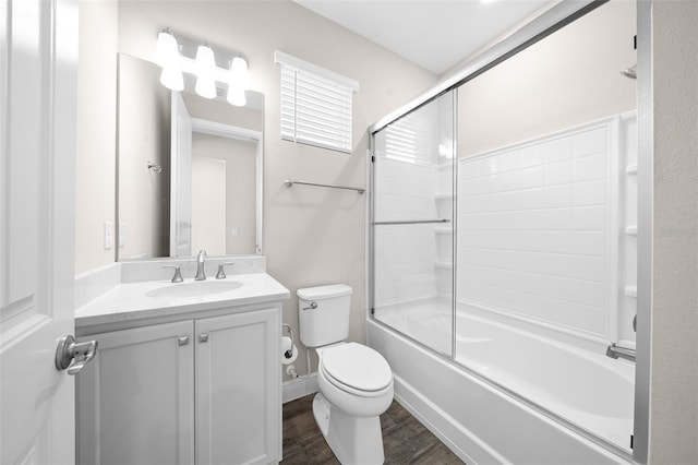 full bathroom with shower / bath combination with glass door, vanity, wood-type flooring, and toilet