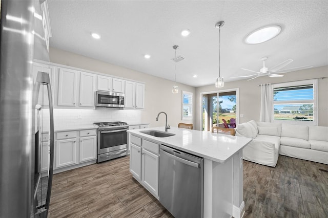 kitchen featuring hanging light fixtures, white cabinetry, sink, and appliances with stainless steel finishes