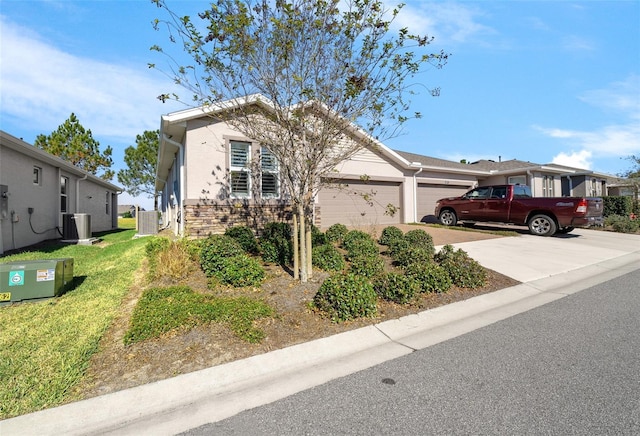 view of front of property with a front yard, central AC, and a garage