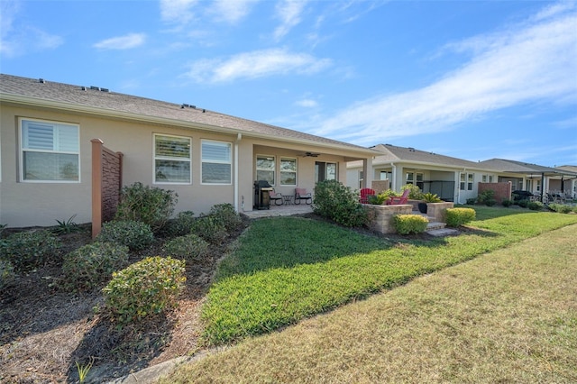 exterior space featuring a patio, ceiling fan, and a lawn