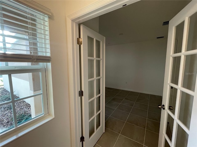 interior space with dark tile patterned floors and french doors