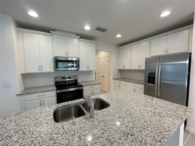 kitchen with sink, white cabinets, and stainless steel appliances