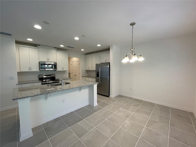 kitchen featuring sink, appliances with stainless steel finishes, tasteful backsplash, light tile patterned flooring, and white cabinetry