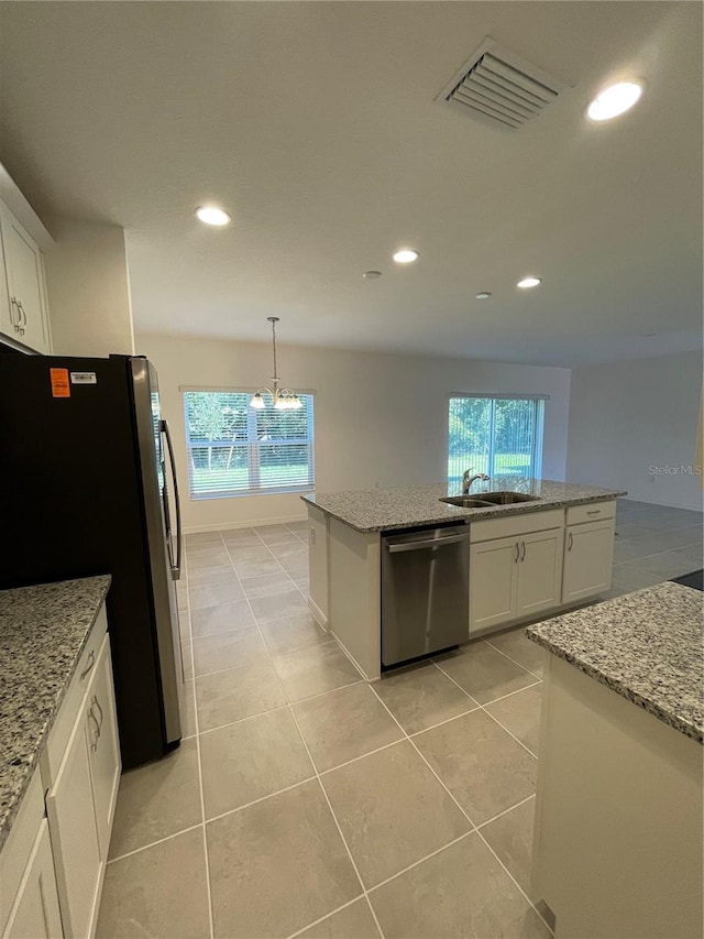 kitchen featuring white cabinets, a center island, hanging light fixtures, and appliances with stainless steel finishes