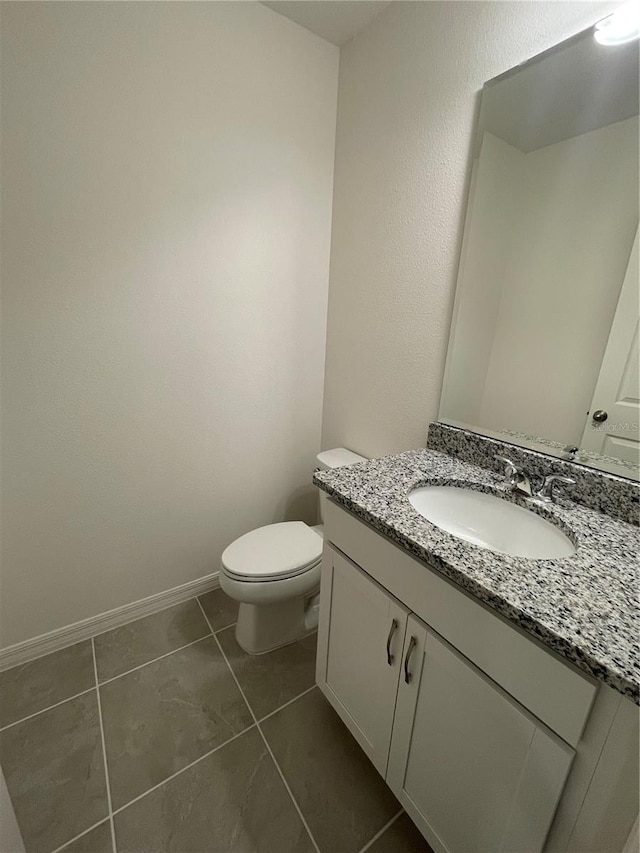 bathroom featuring tile patterned flooring, vanity, and toilet