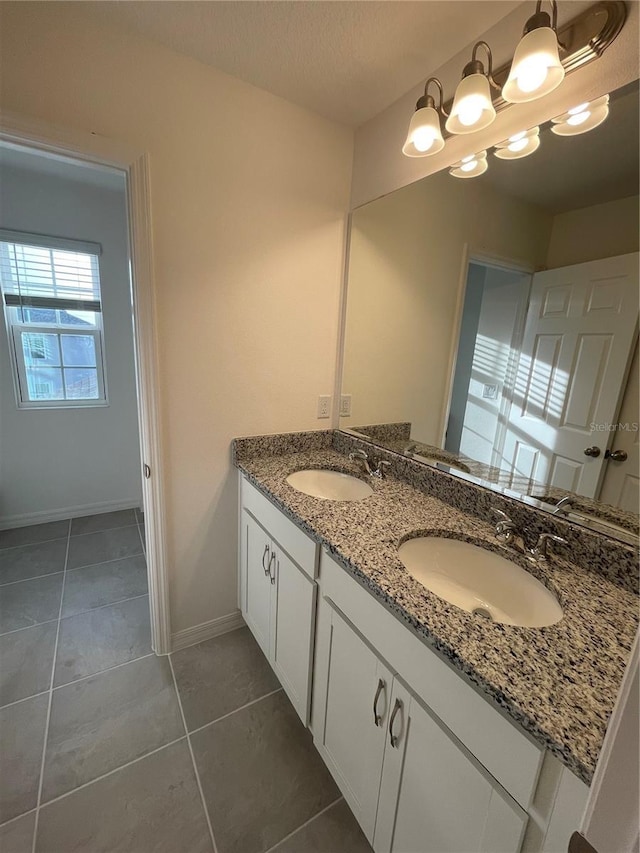 bathroom with a textured ceiling, vanity, and tile patterned floors