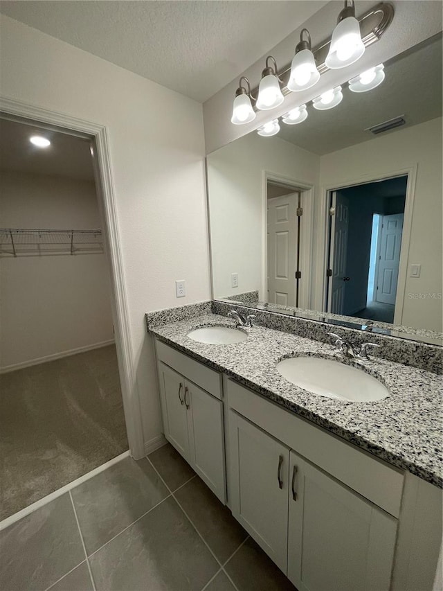 bathroom featuring tile patterned floors, vanity, and a textured ceiling