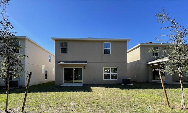 rear view of property with a lawn and central AC unit