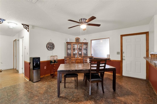 dining area featuring ceiling fan and a textured ceiling