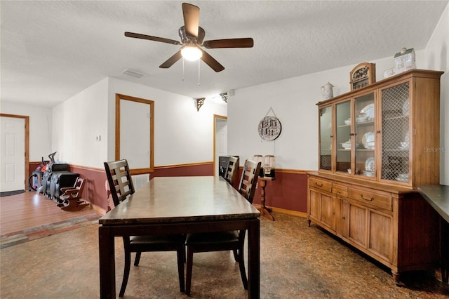 dining room with hardwood / wood-style floors, ceiling fan, and a textured ceiling