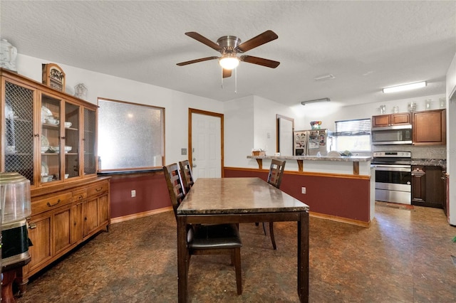 dining room with ceiling fan and a textured ceiling