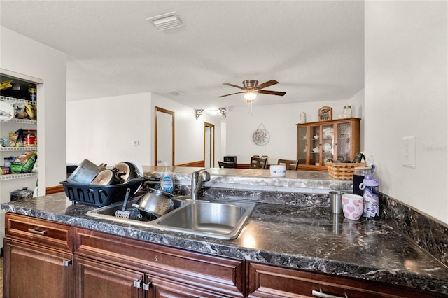 kitchen featuring a textured ceiling, ceiling fan, and sink