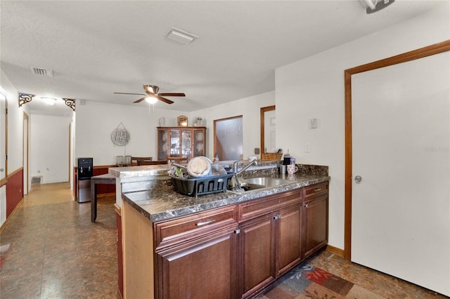 kitchen featuring kitchen peninsula, a textured ceiling, ceiling fan, and sink