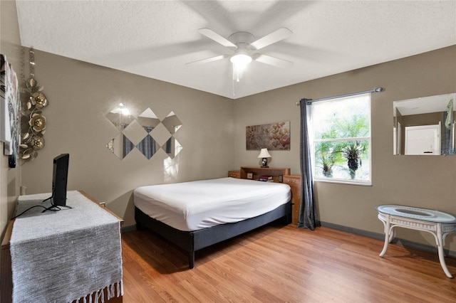 bedroom featuring wood-type flooring, a textured ceiling, and ceiling fan