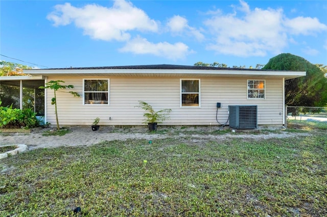 back of house with a lawn, central AC, and a sunroom