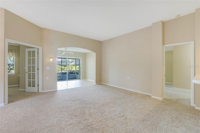 carpeted empty room featuring ceiling fan and french doors