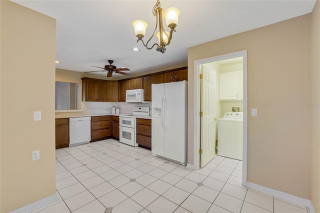 kitchen with ceiling fan with notable chandelier, white appliances, pendant lighting, washer / clothes dryer, and light tile patterned flooring