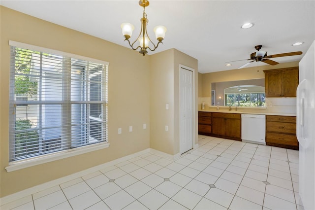 kitchen featuring white appliances, ceiling fan with notable chandelier, sink, hanging light fixtures, and light tile patterned floors