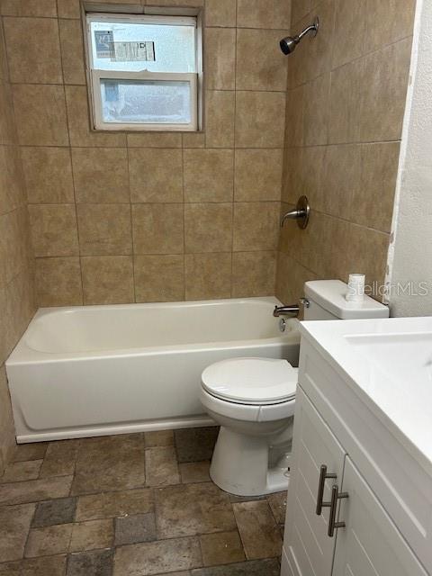 full bathroom featuring vanity, toilet, and tiled shower / bath