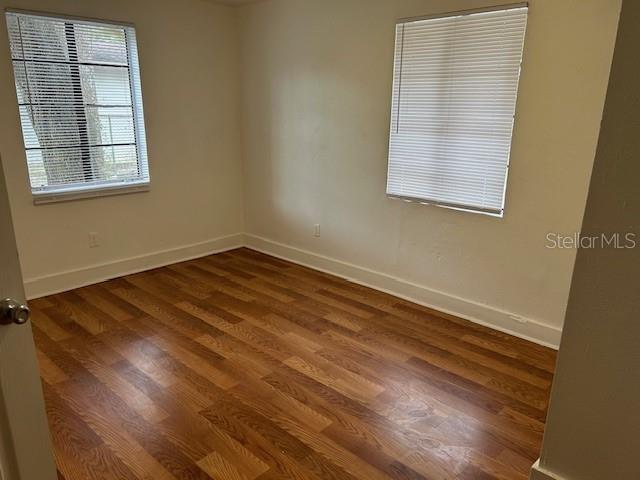 unfurnished room with dark hardwood / wood-style floors