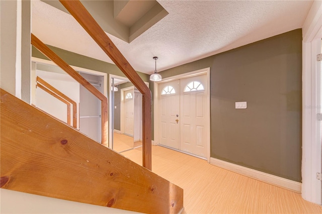 foyer entrance featuring a textured ceiling and hardwood / wood-style flooring